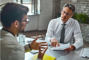 a man in a suit and tie talking to another man