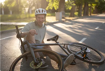 a man sitting on the ground with a bicycle