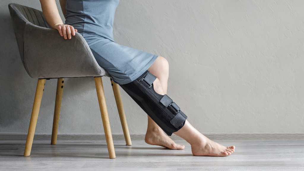 Person in knee brace sitting on a chair