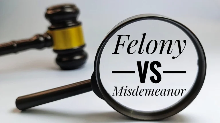 Magnifying glass focusing on text "Felony vs Misdemeanor" with a wooden judge's gavel in background.